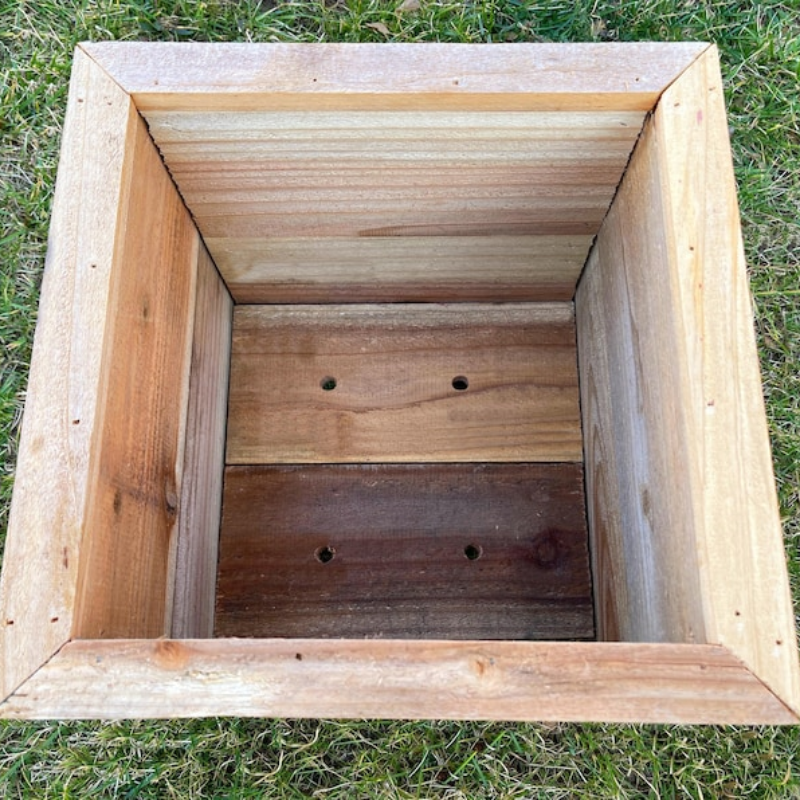 Raised planter filled with fresh vegetables in a well-maintained vegetable garden for optimal growth and harvest.